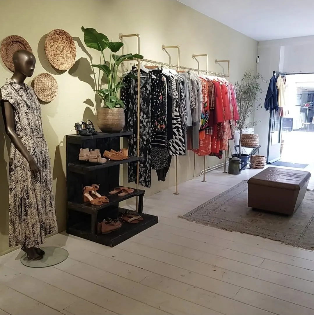 Warm interieur van Felicità aan de Zwanestraat in Groningen, met rekken vintage kleding en natuurlijk licht.
