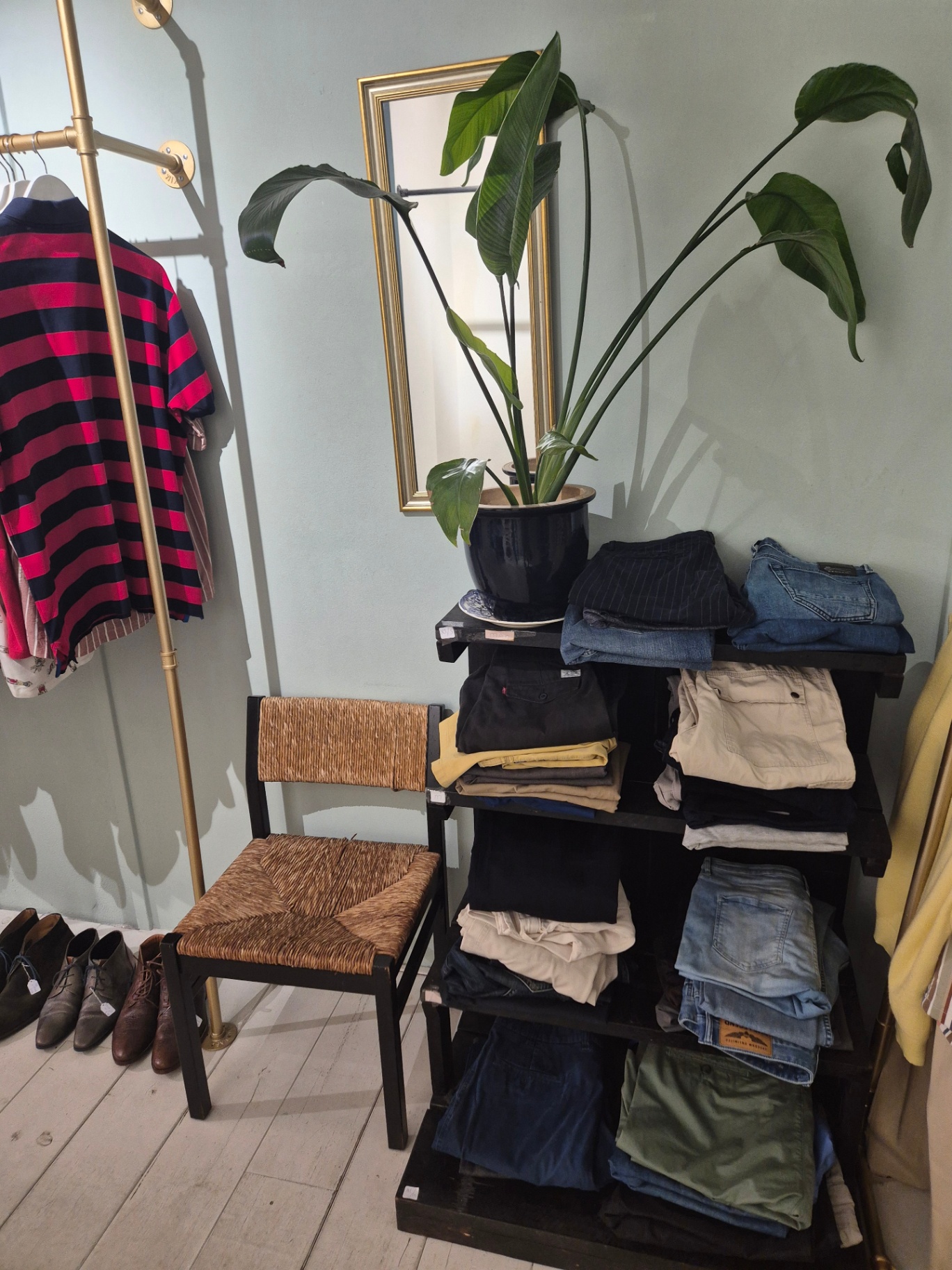 Plank met opgevouwen jeans en chino’s in de herenafdeling van Felicità.