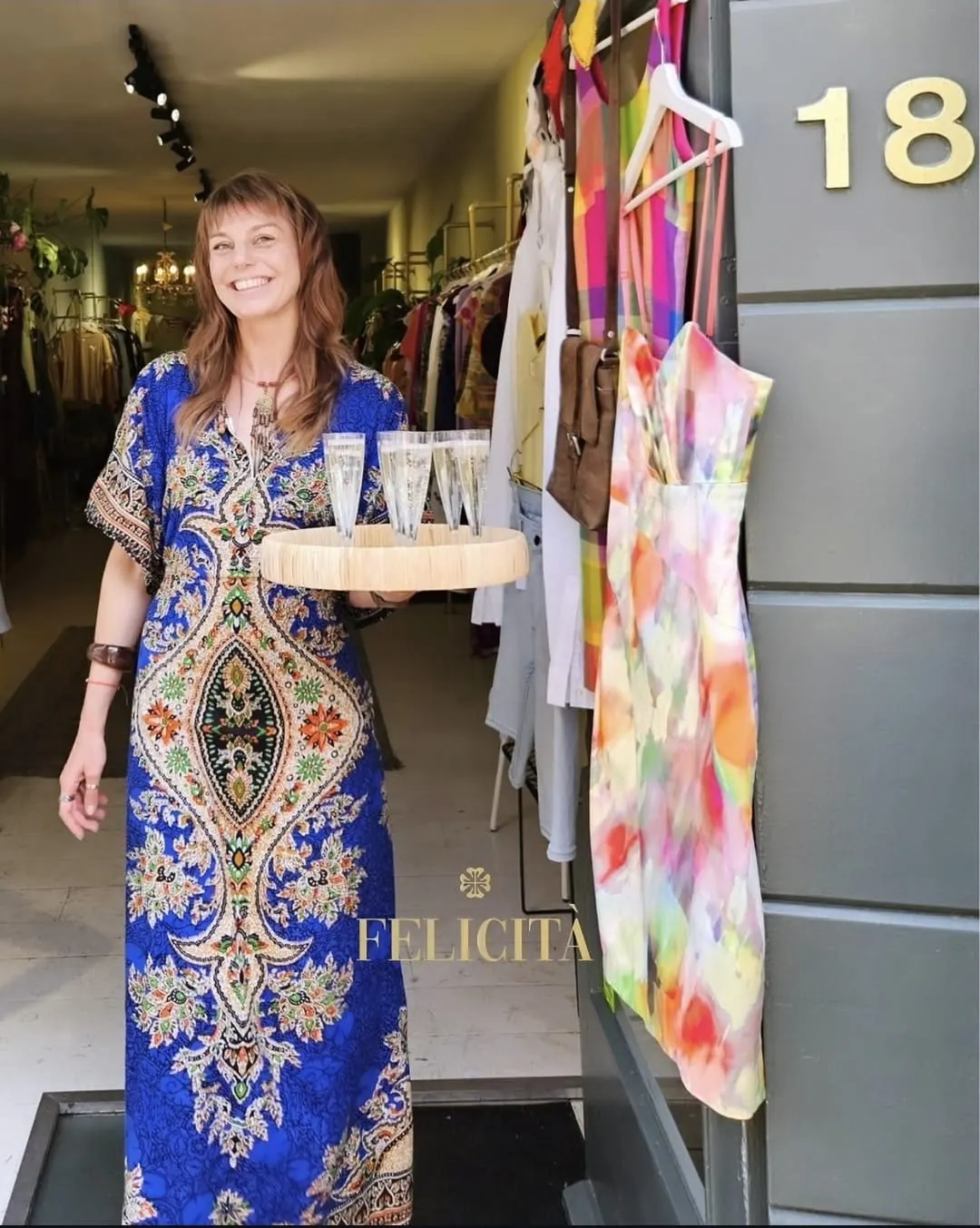 Welkomsttafel met champagne, glazen en bloemen bij binnenkomst in de boutique.